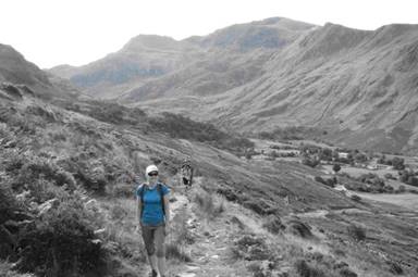 Image may contain: 1 person, smiling, standing, mountain, sky, outdoor and nature